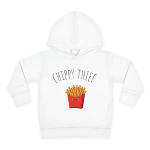 May include: A white hooded sweatshirt featuring a graphic of a red carton filled with golden-brown chips with a smiling face. Above the chips, the text CHIPPY THIEF is printed in a simple black sans-serif font on the front of the garment.