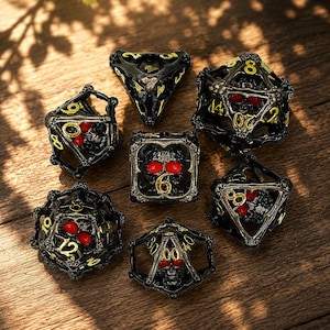 May include: A set of seven polyhedral dice featuring a black metal cage design with intricate skull motifs and bright red accents. Each die has gold-colored numbers engraved on the frame, showcasing various geometric shapes including d20, d12, d10, d8, d6, and d4.