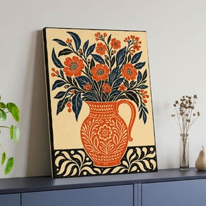 Könnte beinhalten: Ein rechteckiger Wandkunstdruck mit einer Illustration im Holzschnitt-Stil, die einen leuchtend orangefarbenen Krug voller orangefarbener Blumen und dunkelblauer Blätter zeigt. Der Hintergrund ist cremefarben und die Basis hat ein schwarz-weißes Muster.