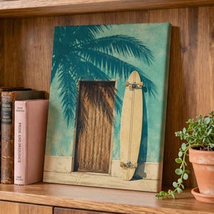 Könnte beinhalten: Ein rechteckiger Leinwanddruck mit einem vertikalen Bild einer Holztür in einer türkisfarbenen Wand, auf die der Schatten einer Palme fällt. Ein helles Longboard-Skateboard steht vertikal an der Wand neben der Tür.