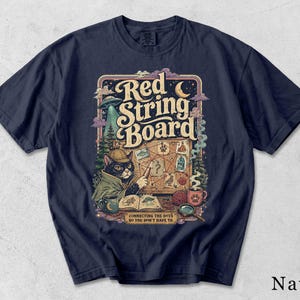 Könnte beinhalten: Ein marineblaues T-Shirt mit einer grafischen Illustration einer Detektivkatze mit Deerstalker-Hut, die auf eine Pinnwand mit rotem Faden zeigt. Der Text lautet Red String Board und Connecting the dots so you don't have to, mit einem UFO und Mond.