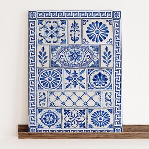 Könnte beinhalten: Ein rechteckiges Wandkunstwerk bestehend aus einem Raster weißer Fliesen mit handgemalten blauen Mustern. Das Design umfasst florale Motive, geometrische Formen und eine griechische Mäanderbordüre, die die gesamte Komposition in Blau und Weiß einrahmt.