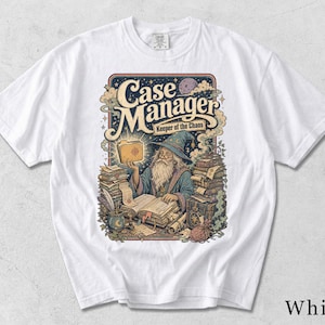 May include: A white t-shirt featuring a graphic illustration of a wizard with a long beard wearing a blue hat and robe. The wizard is surrounded by stacks of books and papers, holding a glowing folder. The text reads Case Manager Keeper of the Chaos.