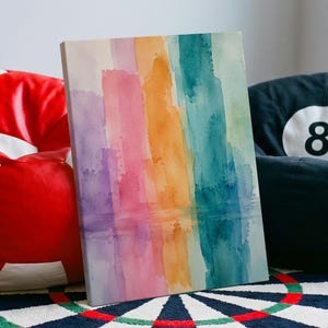 Könnte beinhalten: Ein rechteckiger Leinwanddruck mit vertikalen Aquarellstreifen in den Farben Violett, Pink, Orange, Türkis und Hellblau. Das Kunstwerk zeigt eine weiche, verwaschene Textur mit einem Verlaufseffekt und präsentiert ein lebhaftes Farbspektrum.