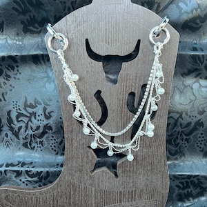 The “Bridal Bootlets” is an intricate strand of chandelier style crystal strand with pearls draped and a single crystal strand (silver).