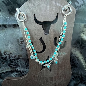 Chain with turquoise color beads and silver color beads paired with silver chain and western charms also turquoise and silver Bootlets.