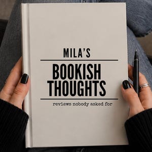 May include: A white hardcover book with black text that reads MILA'S BOOKISH THOUGHTS and reviews nobody asked for. The book is held by two hands, one of which is also holding a black pen. The cover features a clean, minimalist design.