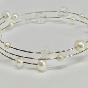 Peut inclure: Un bracelet en fil d'argent avec des perles blanches et des perles de cristal transparentes.