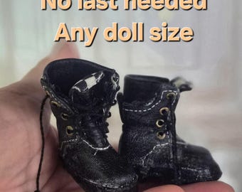 May include: A pair of miniature black doll boots with white stitching and gold-colored eyelets. The boots are held in a hand, and the image includes text that reads "Doll Boots Tutorial No last needed Any doll size."