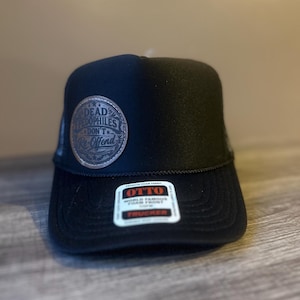 May include: A black trucker hat featuring a circular brown patch on the front panel with the text "DEAD PEDOPHILES DON'T Re-Offend" embossed in black. The brim displays a white sticker with the brand name OTTO and the text "WORLD FAMOUS FOAM FRONT TRUCKER".