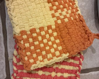 Juego de dos salvamanteles tejidos: amarillo, naranja y rosa.