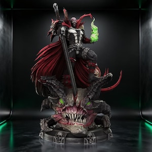 May include: A detailed Spawn action figure standing on a monstrous creature base with a large sword. The character wears a black and white suit with a flowing red cape, holding a glowing green flame in one hand. The base features skulls and teeth.