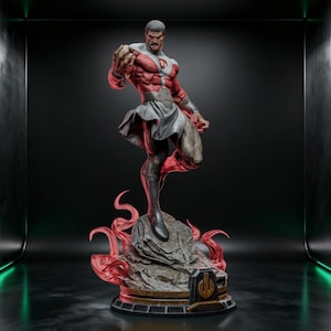 May include: A detailed collectible statue of a muscular superhero figure in a red and white suit with a grey belt and cape. The figure stands on a textured grey rock base surrounded by translucent red flame effects and a gold emblem plaque.