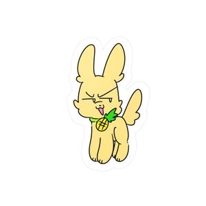 Op de afbeelding: Een gestanste sticker met een cartoonfiguur met lichtgele vacht, lange oren en een sceptische gezichtsuitdrukking. Het figuur draagt een groene halsband met een gele ananasbedel en heeft een kleine staart, getekend in een eenvoudige lijnstijl.
