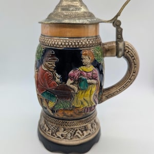 Jarra de cerveza musical antigua, tapa de peltre, escena de taberna de cerámica, caja de música funcional, relieve de querubín
