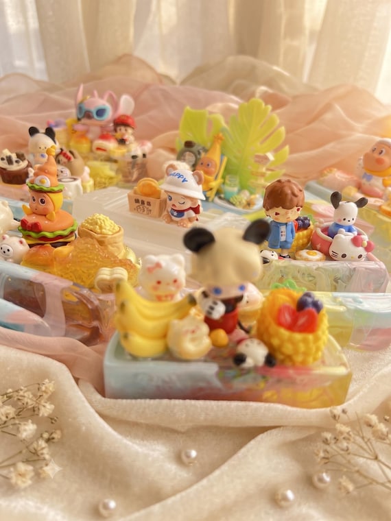 Hand-poured resin 3D character phone stand with kawaii decoden charm — each one is a tiny sculpted art piece that doubles as a functional desk prop.