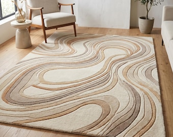 Puede incluir: Una alfombra rectangular que presenta un patrón texturizado en relieve de líneas onduladas, fluidas y orgánicas en tonos crema, beige, tostado y marrón. El diseño crea un efecto topográfico en capas en toda la superficie del revestimiento.