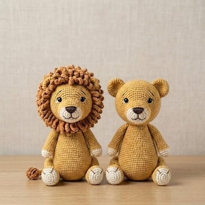 Può includere: Due animali di peluche realizzati a mano all'uncinetto, un leone e un orso, seduti fianco a fianco. Il leone ha una folta criniera riccia color marrone dorato, mentre l'orso ha orecchie arrotondate. Entrambi sono fatti di filato beige e bianco.