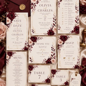 May include: A wedding stationery set featuring cream-colored paper with burgundy and blush floral accents and gold geometric borders. The collection includes an invitation, program, RSVP card, menu, table numbers, and a thank you tag with elegant serif text.