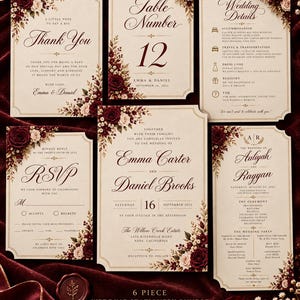 May include: A six-piece wedding stationery bundle featuring cream-colored cards with dark red and white floral accents. The set includes an invitation, RSVP card, thank you note, table number, wedding details, and a program, all with elegant script.