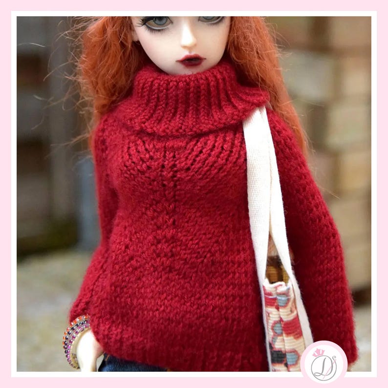 May include: A doll wearing a red knitted turtleneck sweater. The sweater has a textured pattern and long sleeves. The doll has red hair, pale skin, and is carrying a white tote bag with a patterned design.