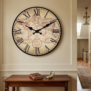 May include: A large round wall clock featuring a vintage-style world map on its face with black Roman numerals and black metal hands. The clock has a thin black circular frame and displays a detailed cartographic design with beige tones.