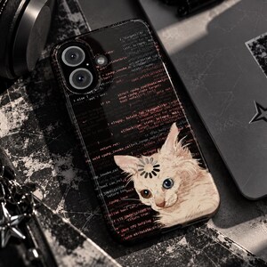 May include: A black smartphone case featuring a background of red computer code text and a graphic of a light-coloured cat with a loading icon on its forehead. The case has a dual-lens camera cutout at the top left corner and a glossy finish.