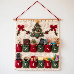 May include: A cream-colored crocheted wall hanging featuring a Christmas tree, red bows, and twelve numbered pockets in alternating red and green. Each pocket contains various small items like keys, a wallet, a plant, and stationery.