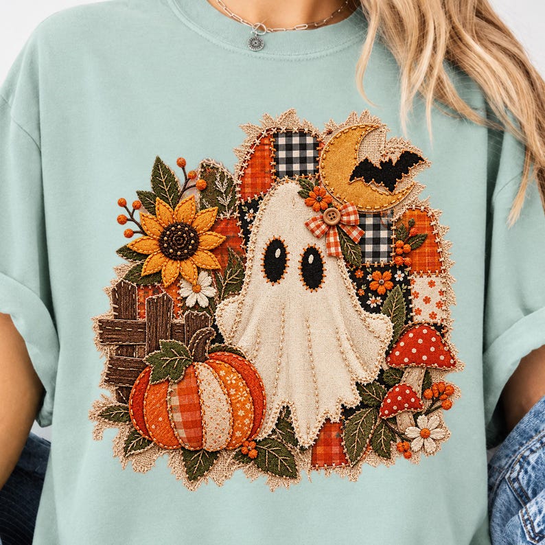 Peut inclure: Un t-shirt vert clair avec un motif central repr&eacute;sentant un fant&ocirc;me blanc, une citrouille orange, un tournesol jaune, des champignons rouges et un croissant de lune. Le design int&egrave;gre des textures de tissu &agrave; carreaux et vichy.