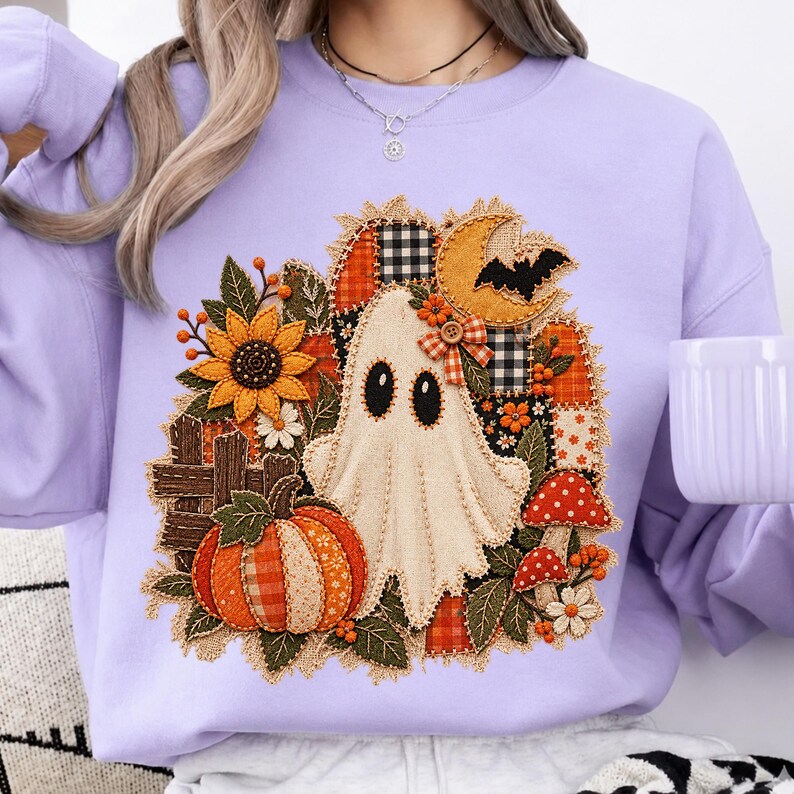 Peut inclure: Un sweat-shirt &agrave; col rond violet clair avec un motif central repr&eacute;sentant un fant&ocirc;me, une citrouille, un tournesol, des champignons et un croissant de lune avec une chauve-souris. Le design int&egrave;gre des textures, des carreaux et un petit n&oelig;ud.