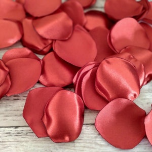 May include: A pile of red satin rose petals, perfect for weddings, special events, or romantic decor.