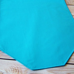 Peut inclure: Un chemin de table hexagonal de couleur bleu turquoise. Le chemin de table est fait d'un tissu doux et lisse avec un léger brillant.