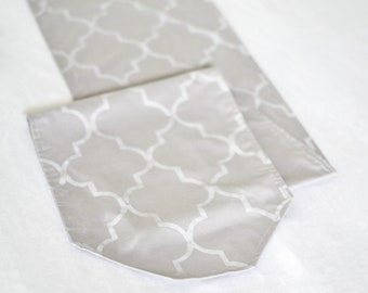 Moroccan style silver colored table runner, hand stenciled white quatrefoil pattern on light gray