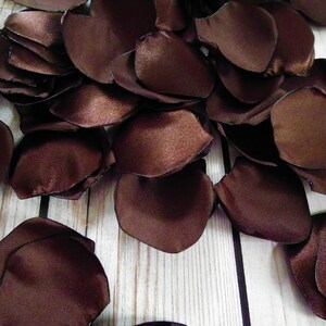 Pode incluir: Um monte de pétalas de rosa de cetim marrom, perfeitas para decorações de casamento ou eventos especiais.