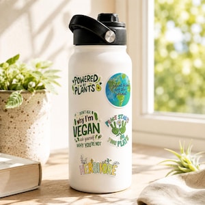 May include: A white water bottle with a black lid featuring several stickers: Powered by Plants, a globe with plant based for the planet, Don't ask why I'm vegan ask yourself why you're not, Peace starts on your plate, and Herbivore.