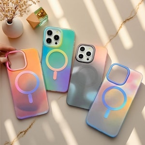 May include: Four rectangular smartphone cases with circular magnetic charging rings on the back. The cases feature gradient color schemes in orange, yellow, green, blue, and purple, with one case appearing in a translucent dark gray finish.
