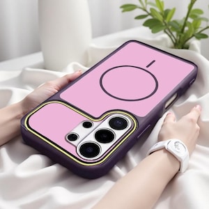May include: A dark purple smartphone case featuring a light pink back panel with a circular magnetic charging ring design. The camera module area is highlighted with a yellow border and contains multiple circular lens cutouts for the phone.