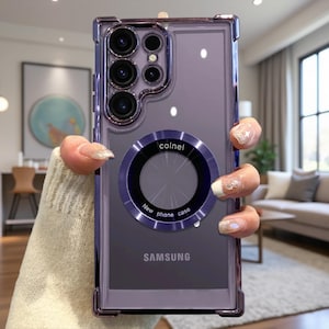 Puede incluir: Una funda de smartphone morada con acabado metálico y esquinas reforzadas. La parte trasera presenta un anillo magnético circular con el texto colnel y New phone case impreso. La palabra SAMSUNG está impresa en la parte inferior.