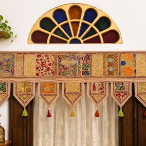May include: A rectangular window valance featuring a patchwork of embroidered fabric panels in gold, red, green, and blue tones. The valance has seven pointed, hanging tabs, each finished with a small, colourful tassel at the bottom point.