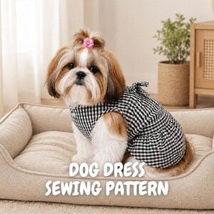 Puede incluir: Un perro Shih Tzu con un accesorio de pelo de flor rosa lleva un vestido de cuadros vichy en blanco y negro. El texto DOG DRESS SEWING PATTERN aparece en letras blancas en la parte inferior. El perro está sentado en una cama beige rectangular.