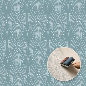 Pode incluir: Um padrão de papel de parede azul com linhas brancas repetitivas de folhas estilizadas e pontos. Uma imagem circular inserida mostra um rolo de pintura aplicando um design botânico semelhante em azul sobre uma superfície clara.