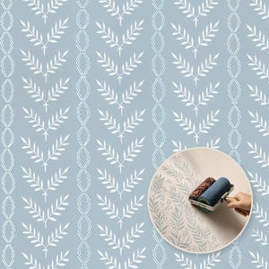 May include: A wall stencil pattern featuring repeating white leaf sprigs and vertical diamond outlines on a light blue background. An inset circle shows a blue paint roller applying a similar botanical design onto a flat, light-colored surface.