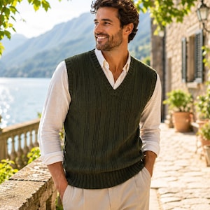 Può includere: Un gilet a maglia con scollo a V in verde oliva scuro caratterizzato da un motivo a coste verticali. Il capo è indossato sopra una camicia bianca a maniche lunghe con le maniche arrotolate, abbinato a pantaloni beige chiaro.