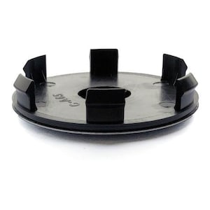 Peut inclure: Un cache-moyeu de roue circulaire en plastique noir doté de cinq clips de fixation régulièrement espacés sur le bord extérieur et d'une ouverture centrale. La surface porte l'inscription en relief C-465 près du trou central.