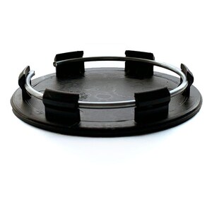 May include: A circular black plastic wheel center cap featuring a flat top surface and a series of black mounting clips arranged around the perimeter. A thin, silver-toned metal tension ring is threaded through the clips to secure the component.