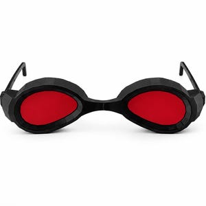 May include: Black sunglasses with a faceted, geometric frame design and solid red lenses. The eyewear features a bridge connecting the two circular-shaped rims and thin black temples extending from the sides of the thick, angular outer edges.