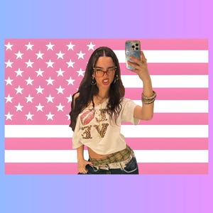 Può includere: Una t-shirt bianca con una stampa grafica di un labbro rosso e la parola LOVE in fantasia leopardata. La maglietta è indossata con jeans blu scuro, una fascia in vita a quadri, una cintura chiara e diversi anelli e collane color oro.