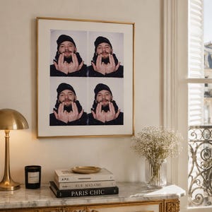 Peut inclure: Une œuvre d'art murale carrée encadrée présentant une grille de quatre portraits photographiques identiques d'une personne portant un bonnet noir et des vêtements sombres, les deux mains levées. L'impression est dans un cadre doré fin.