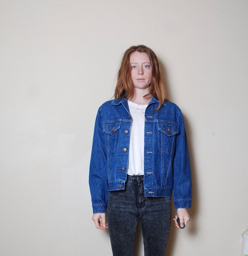 Puede incluir: Una chaqueta vaquera azul con cierre de botones y dos bolsillos delanteros. La chaqueta tiene un estilo cl&aacute;sico y est&aacute; hecha de un material duradero.