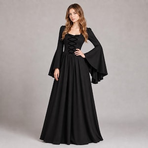May include: A floor-length black dress featuring long, wide bell sleeves and a square neckline. The bodice includes a central vertical lace-up detail with black ribbon ties, transitioning into a full, flowing skirt that reaches the floor.